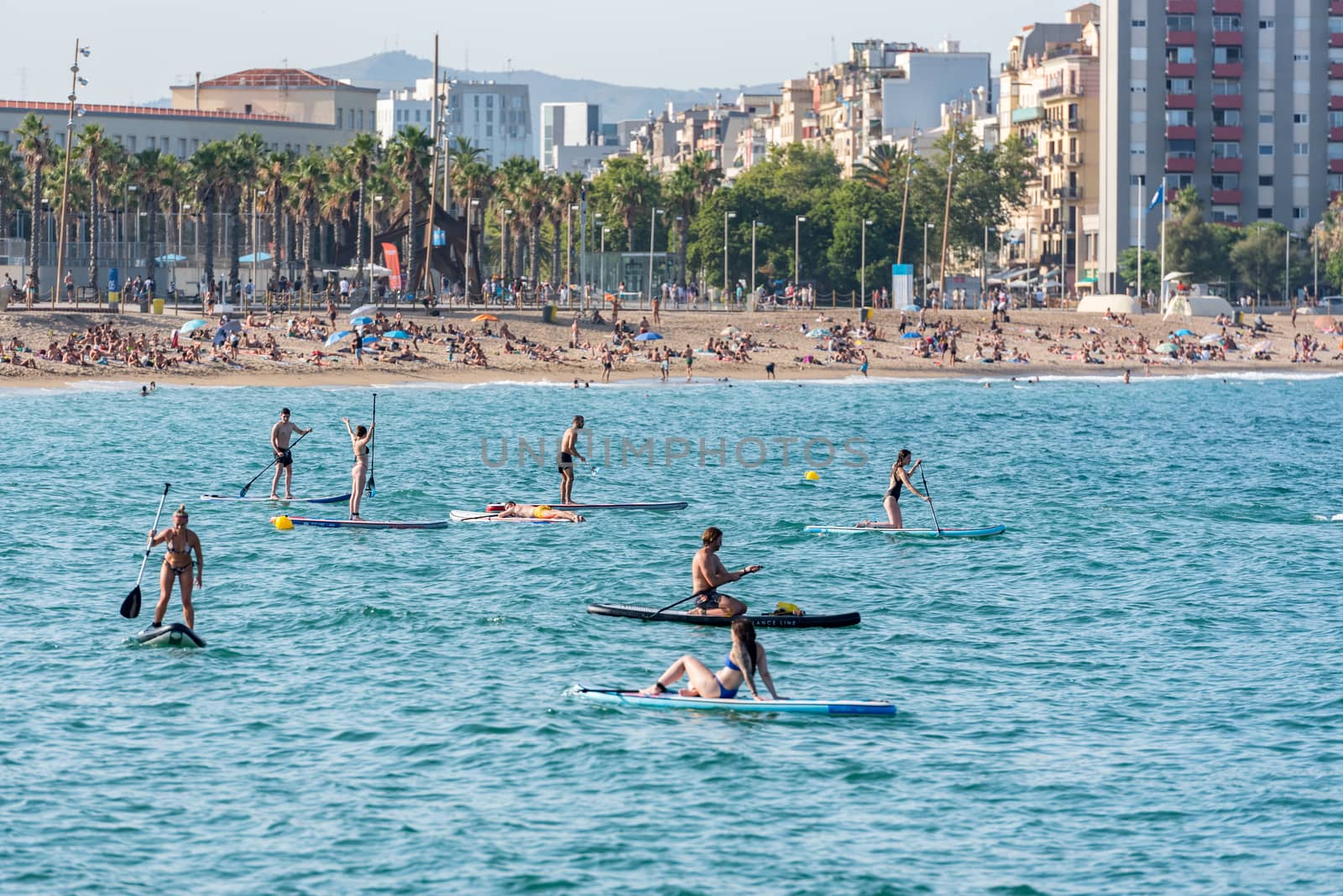 Barcelona, Spain - July 28 2020:  People riding Paddle Surf after COVID 19 La Barceloneta in Barcelona, Spain.