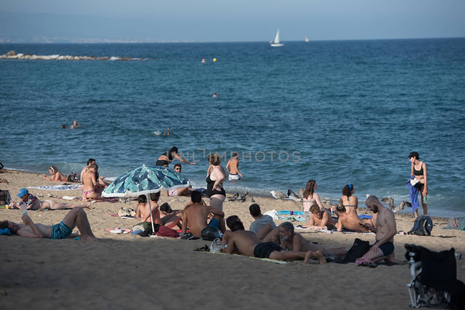Barcelona, Spain - July 28 2020:  People in the Barceloneta Beach after COVID 19 La Barceloneta in Barcelona, Spain.