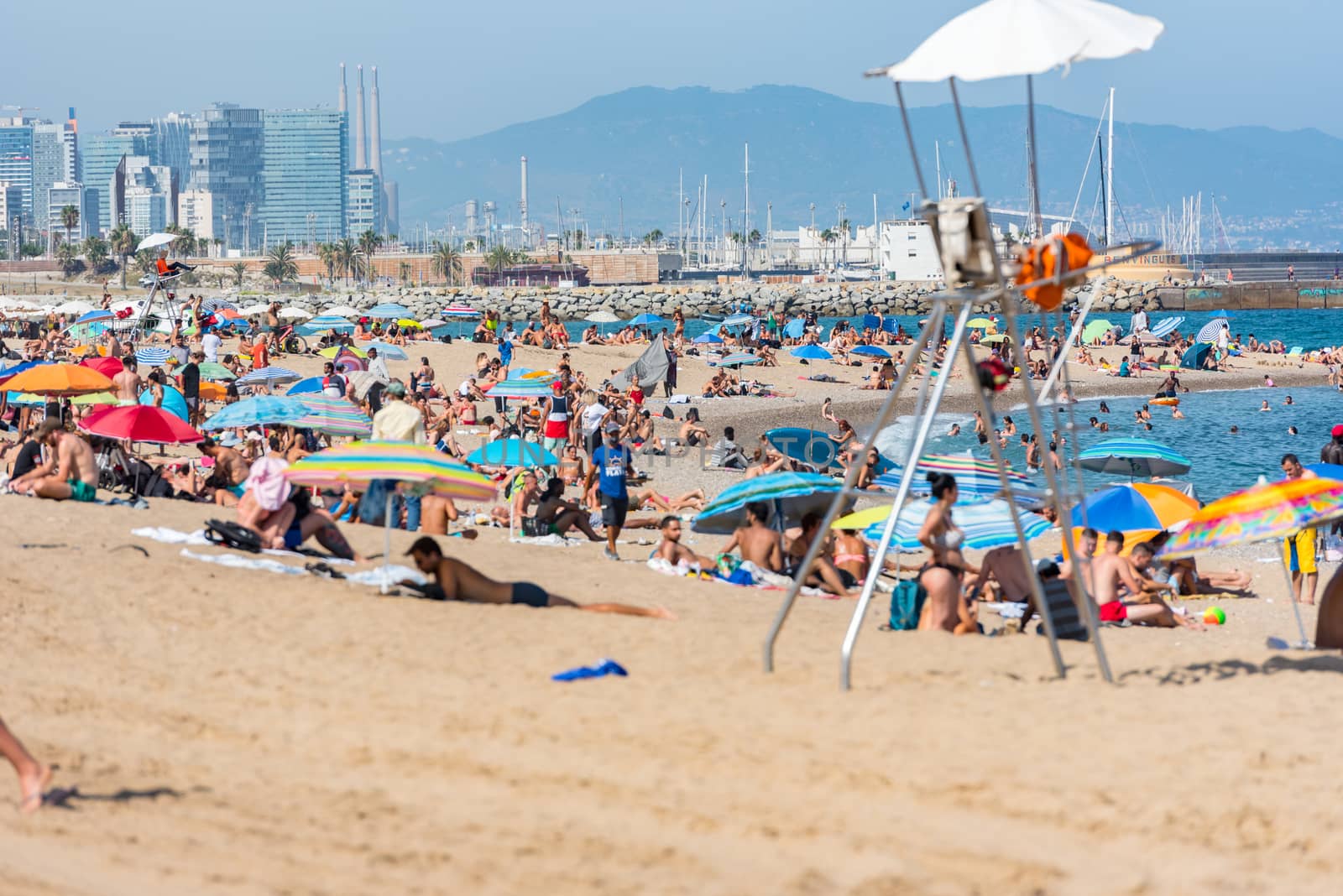 Barcelona, Spain - July 28 2020:  People in the Barceloneta Beach after COVID 19 La Barceloneta in Barcelona, Spain.