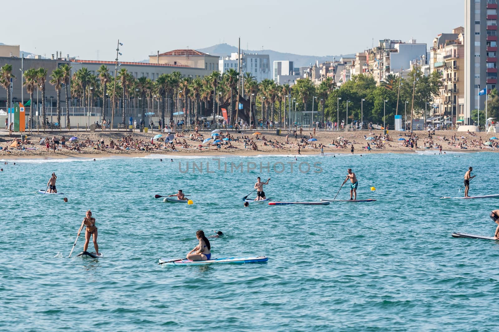 Barcelona, Spain - July 28 2020:  People riding Paddle Surf after COVID 19 La Barceloneta in Barcelona, Spain.