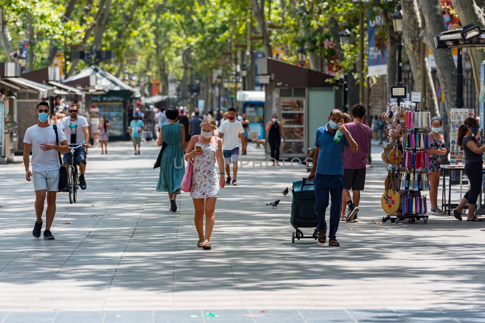 Barcelona, Spain - July 28 2020:  People walking through empty streets after COVID 19 in Barcelona, Spain.