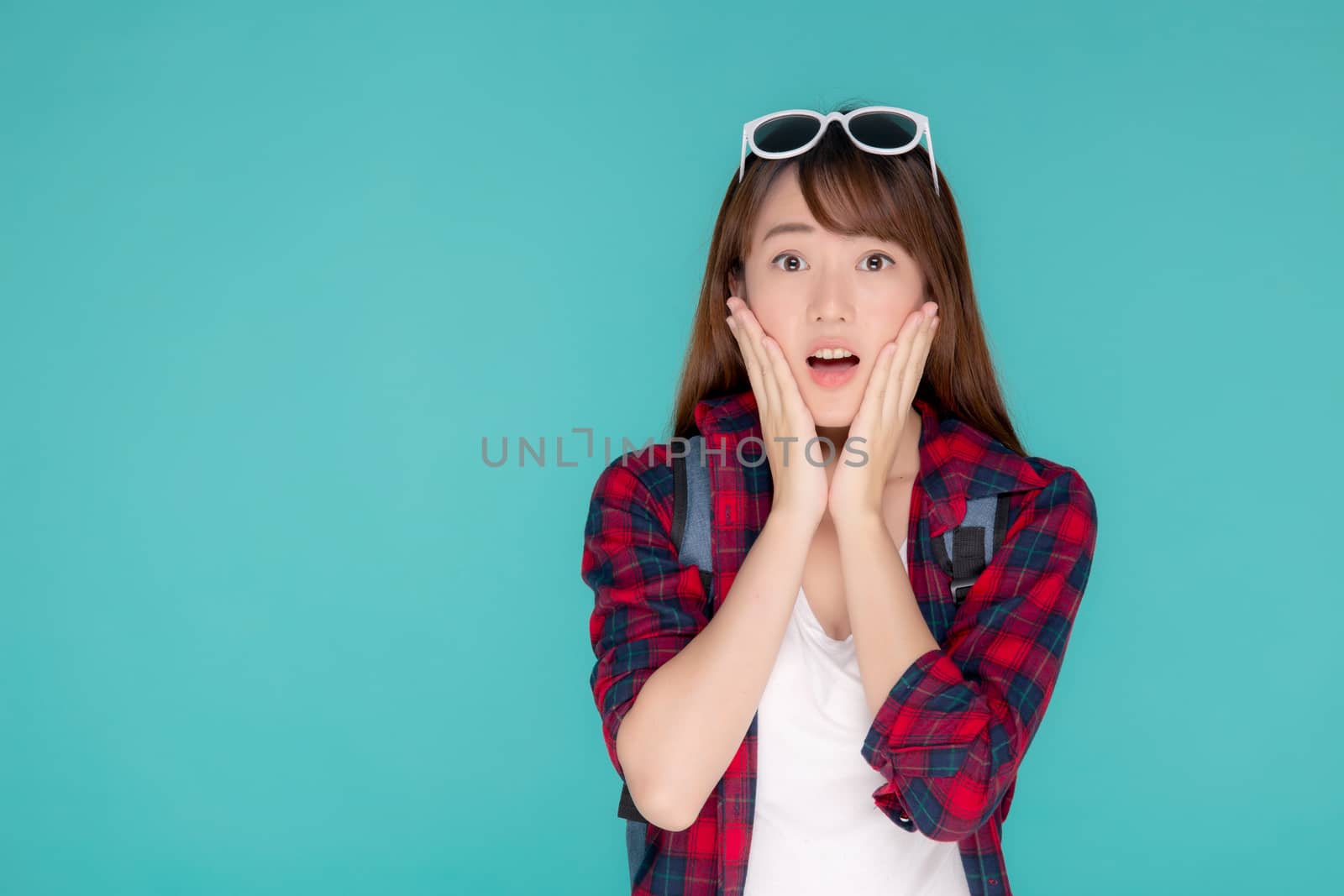 Beautiful portrait young asian woman surprise wearing travel summer fashion with tourist in vacation isolated on blue background, girl shocked expression and emotion, holiday amazing concept.