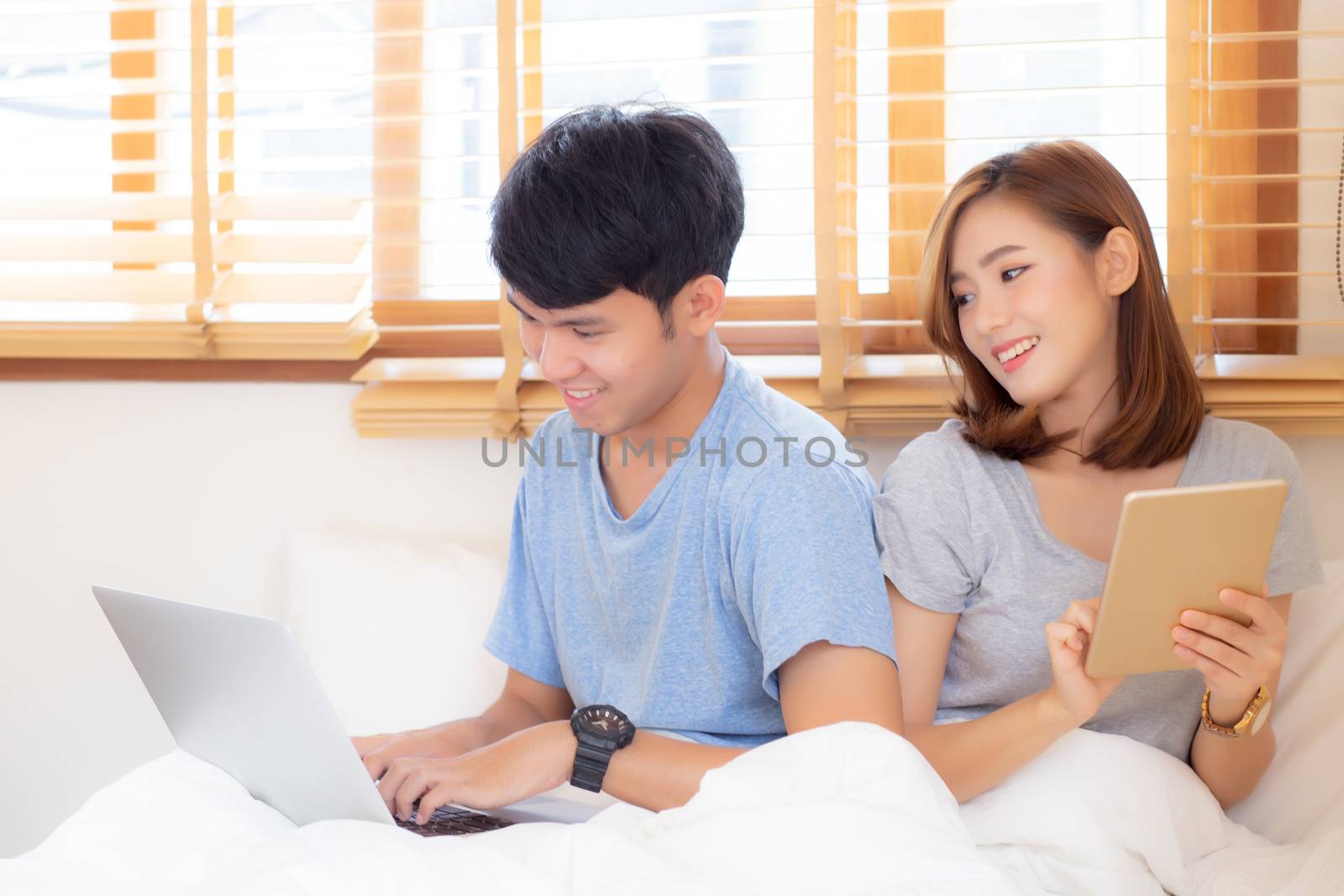 Beautiful young asian couple cheerful freelance working with man by nnudoo