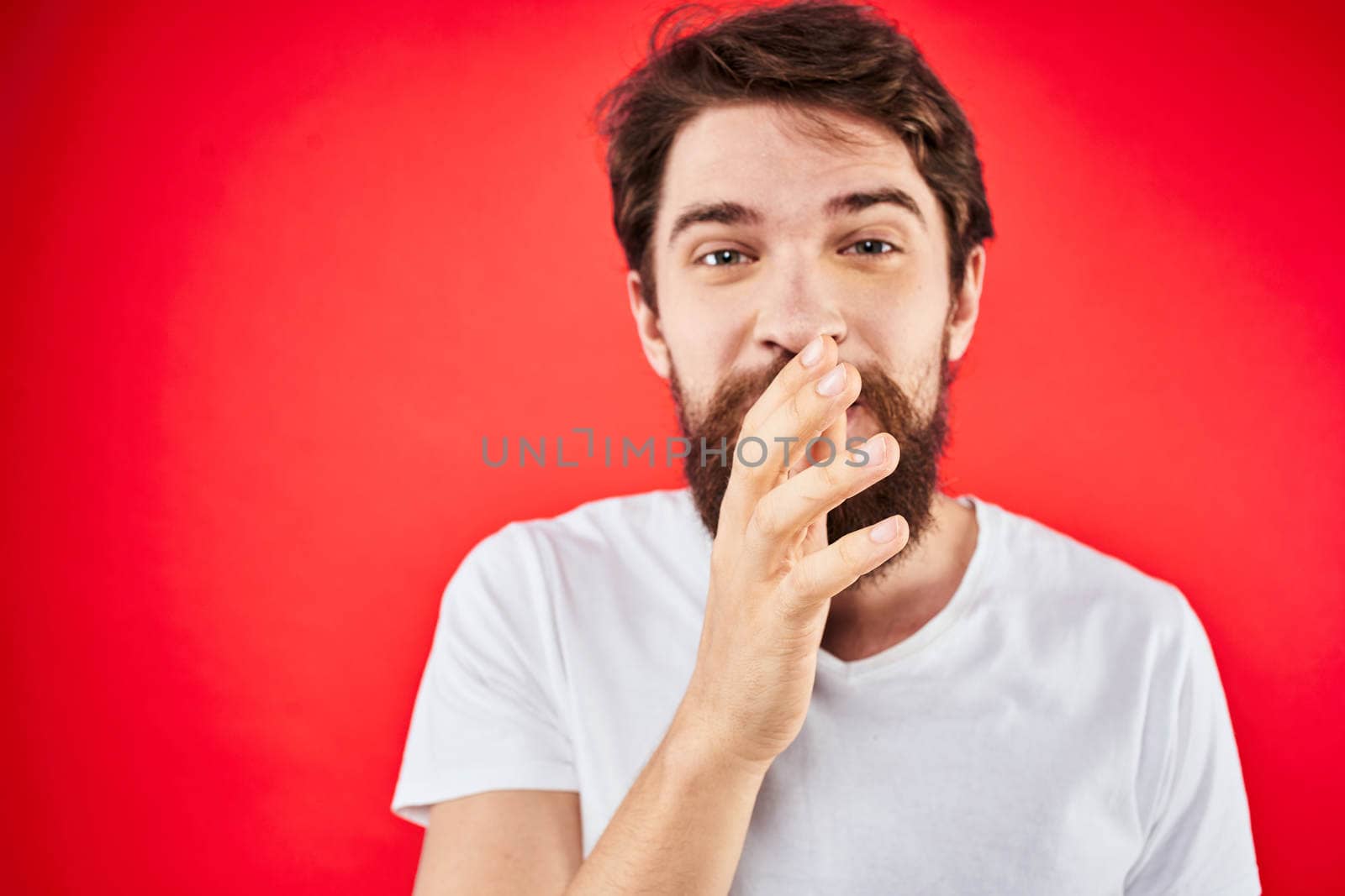 Bearded man fun emotions lifestyle cropped view white t-shirt red background by SHOTPRIME
