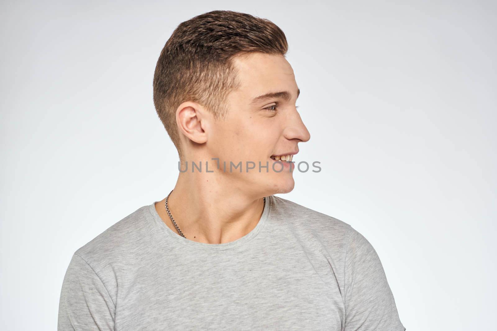 Handsome man in gray t-shirt cropped view of emotion Studio Model. High quality photo