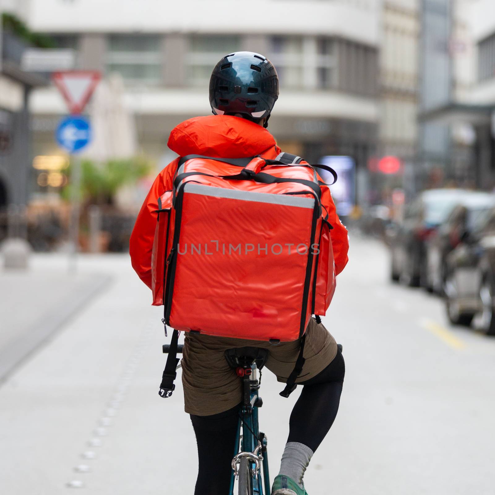 Courier On Bicycle Delivering Food In City. by kasto