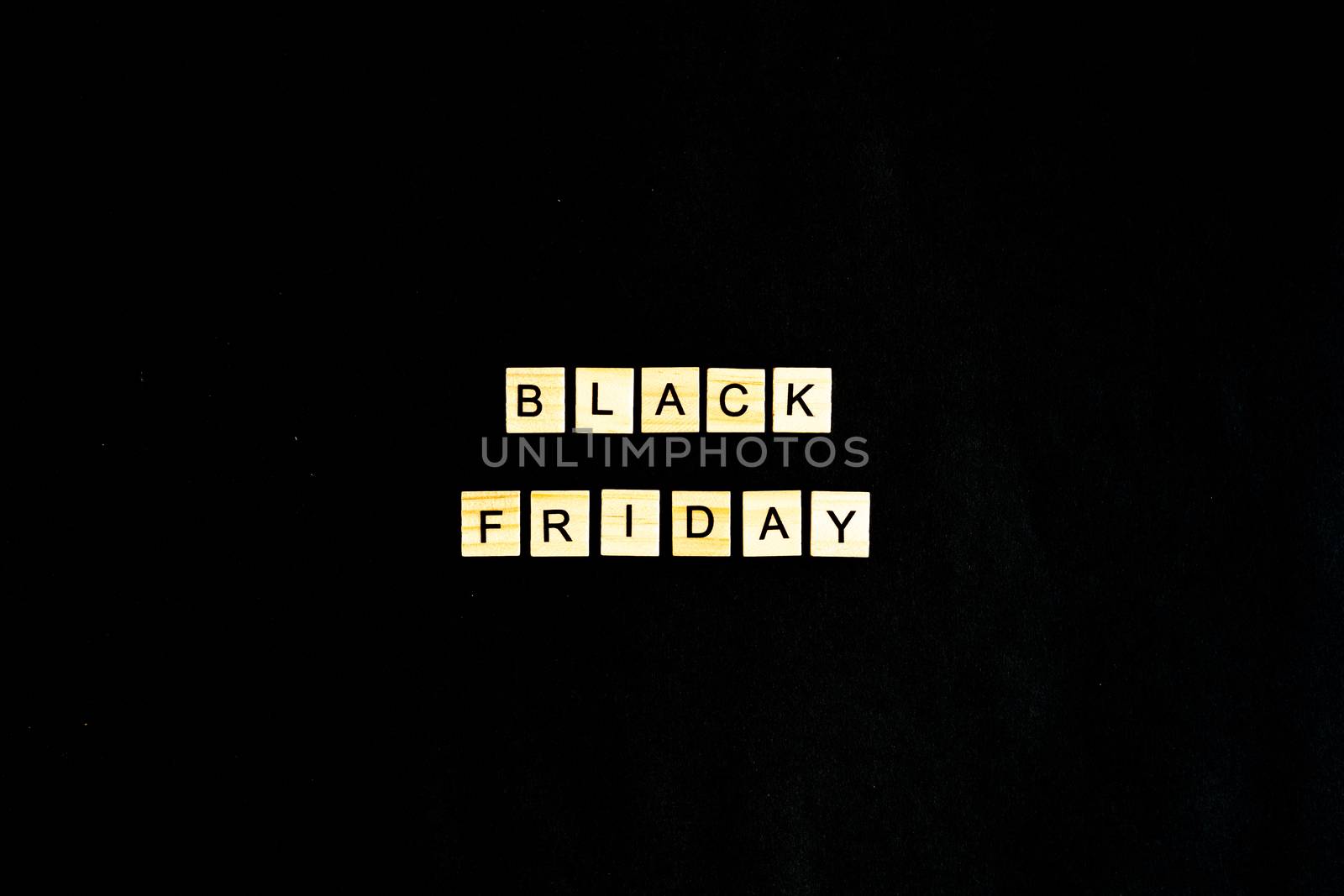 Black Friday written in wooden letters on a black background, sales, holiday sales, top view, flat layout, price reduction.