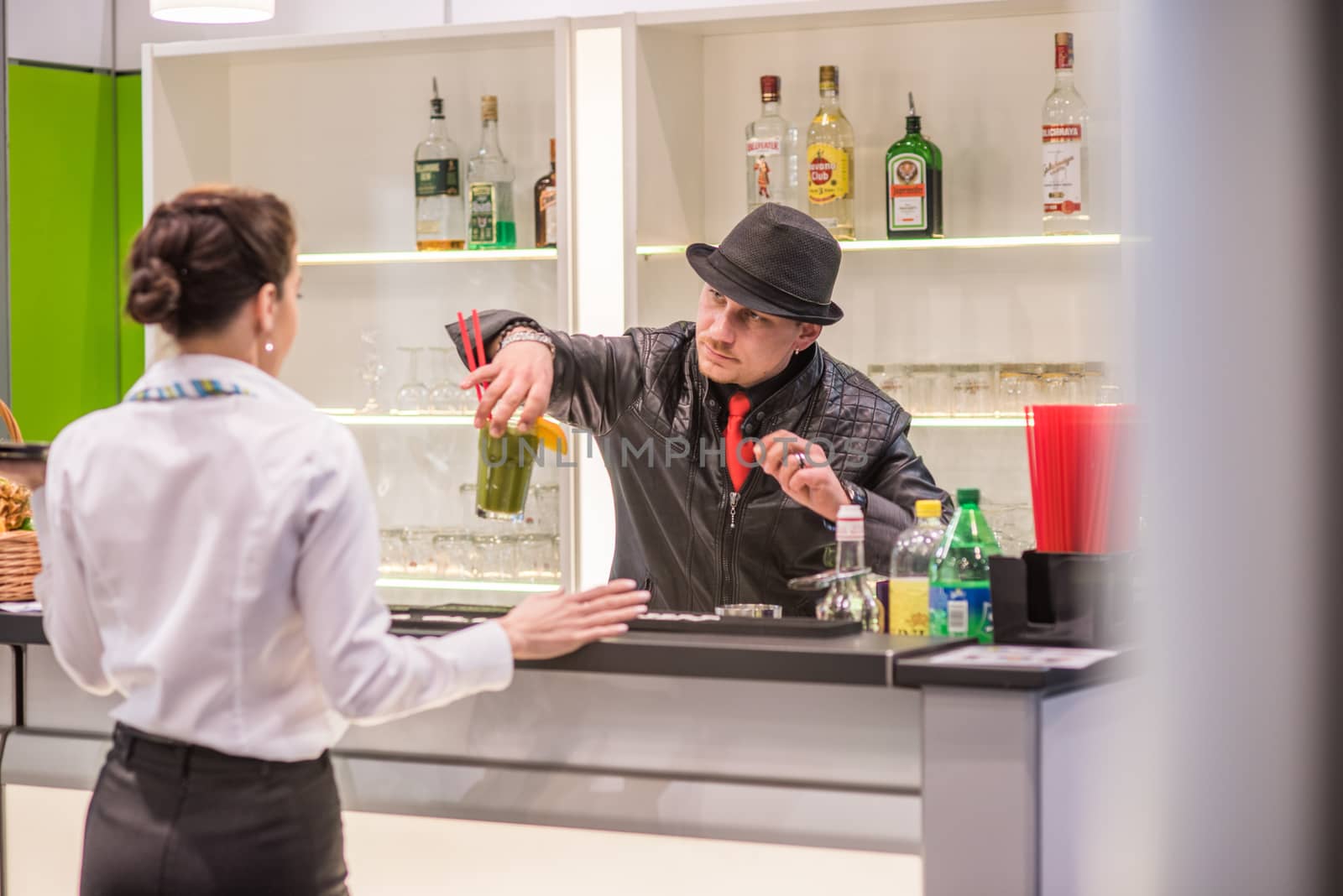 A experienced barman is preparing and serving a colorful cocktail at the Amper convention at the Bno Exhibition Center. czech Republic