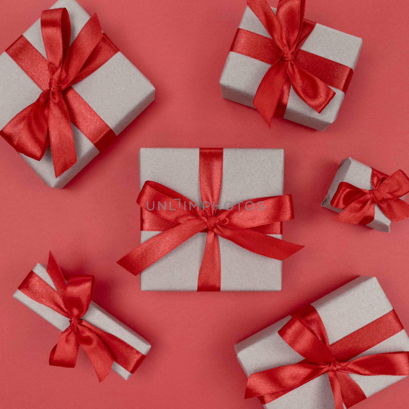 Gift boxes wrapped in craft paper with red ribbons and bows. Festive monochrome flat lay