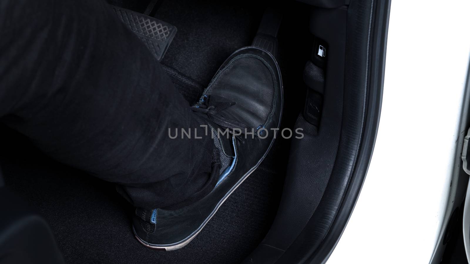 Close up images of man driving car by pushing accelerator and brake pedal with right foot black leather shoe and black jean pant. camera shot inside the japanese car.