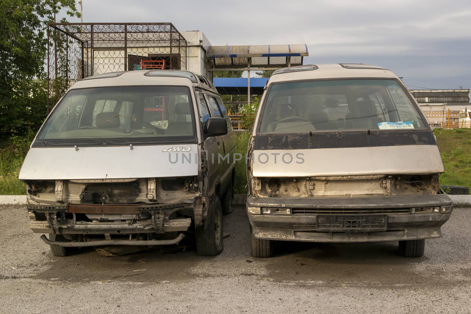 stand nearby in the street two half-disassembled minibuses