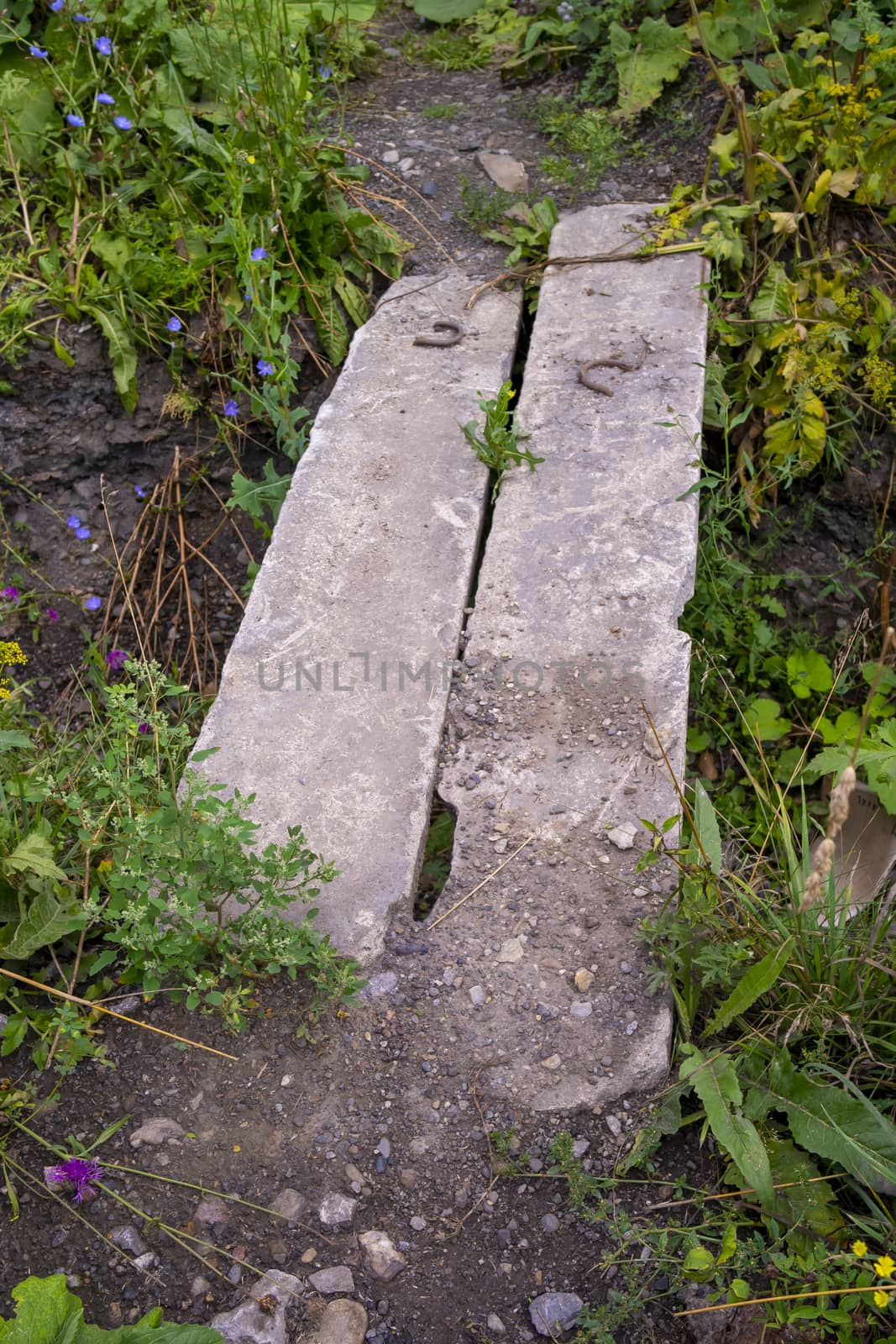 bridge of two concrete blocks across a shallow ditch by Akmenra