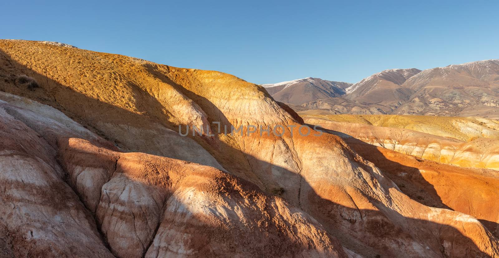 Panoramic shot of massive red mountains in Kyzyl-Chin valley, also called Mars valley. Blue sky as a background. Altai, Siberia, Russia by DamantisZ