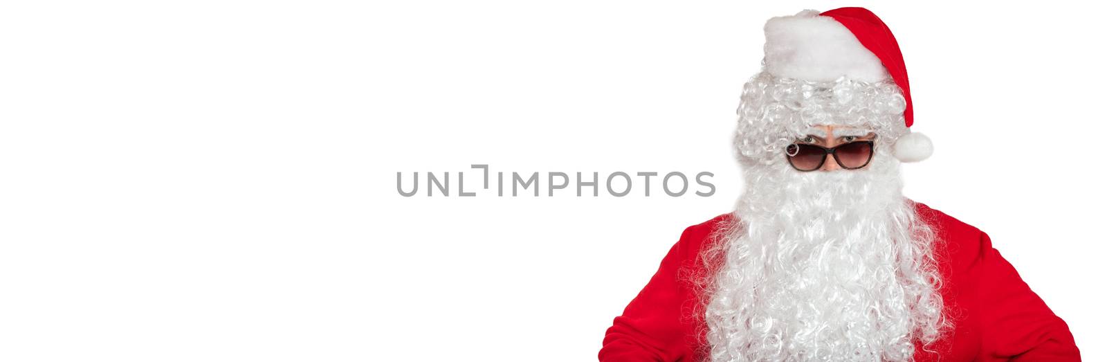 Santa Claus looking straight at the camera He looks angry and serious. He is wearing sunglasses, long white beard. Isolated on white background. Banner size, copy space by DamantisZ