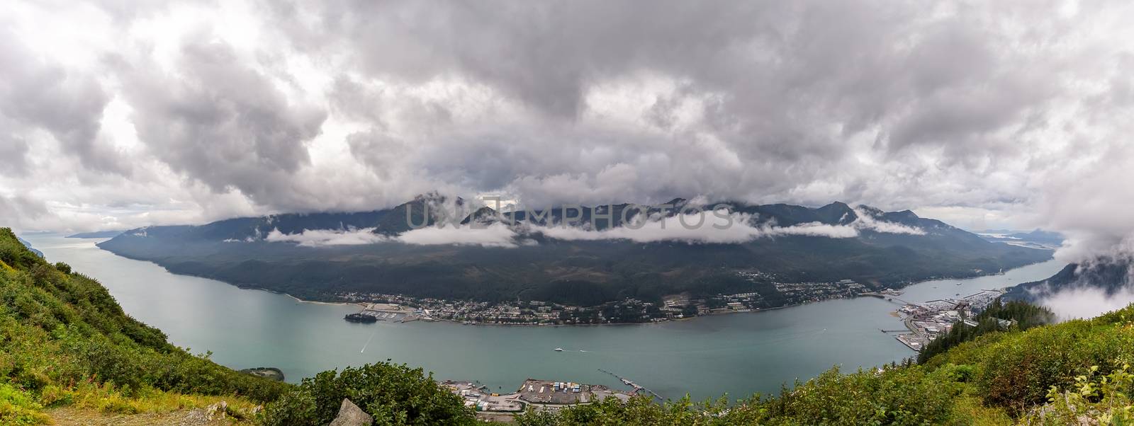Panoramic view of Gastineau Channel, port of Juneau and mountains covered with clouds from the top of mountain Roberts in Alaska by DamantisZ