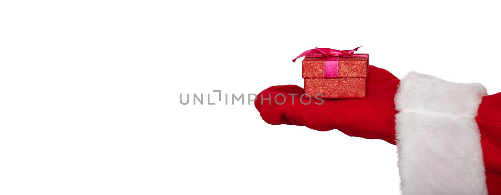 Santa Claus's hand holding a red box with a ribbon. Christmas gift concept. Isolated on white background. Banner size, copy space.