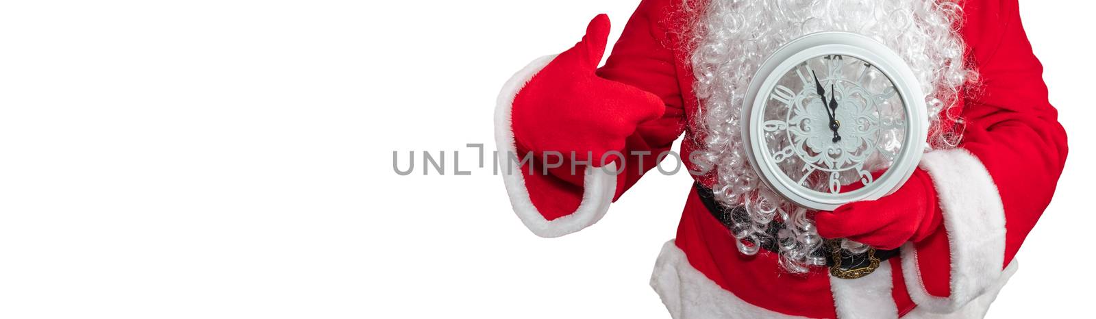 Santa Claus holding a white clock which shows five minutes to midnight and he is pointing at it. New year's eve concept. Isolated on white background. Banner size, copy space.