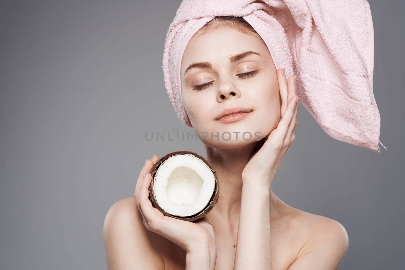 Cheerful woman with coconut in hand enjoying pure skin spa treatments. High quality photo