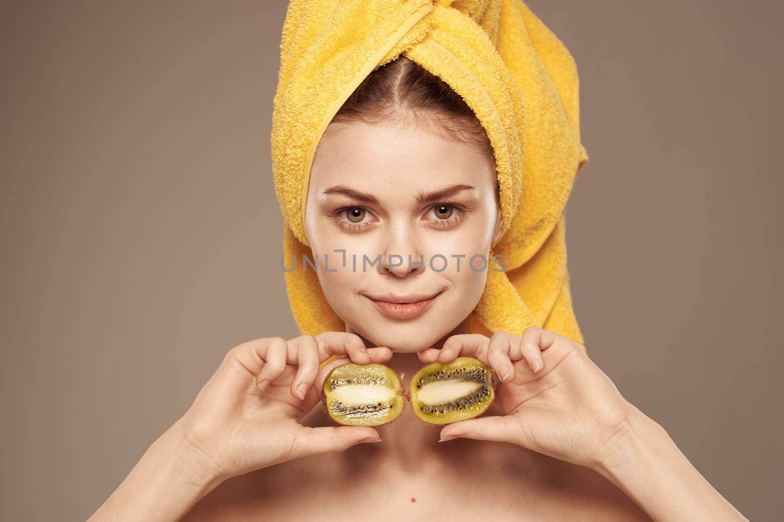 Woman is healthy there with a towel on her head clean leather fruit kiwi vitamins rejuvenation beige background by SHOTPRIME