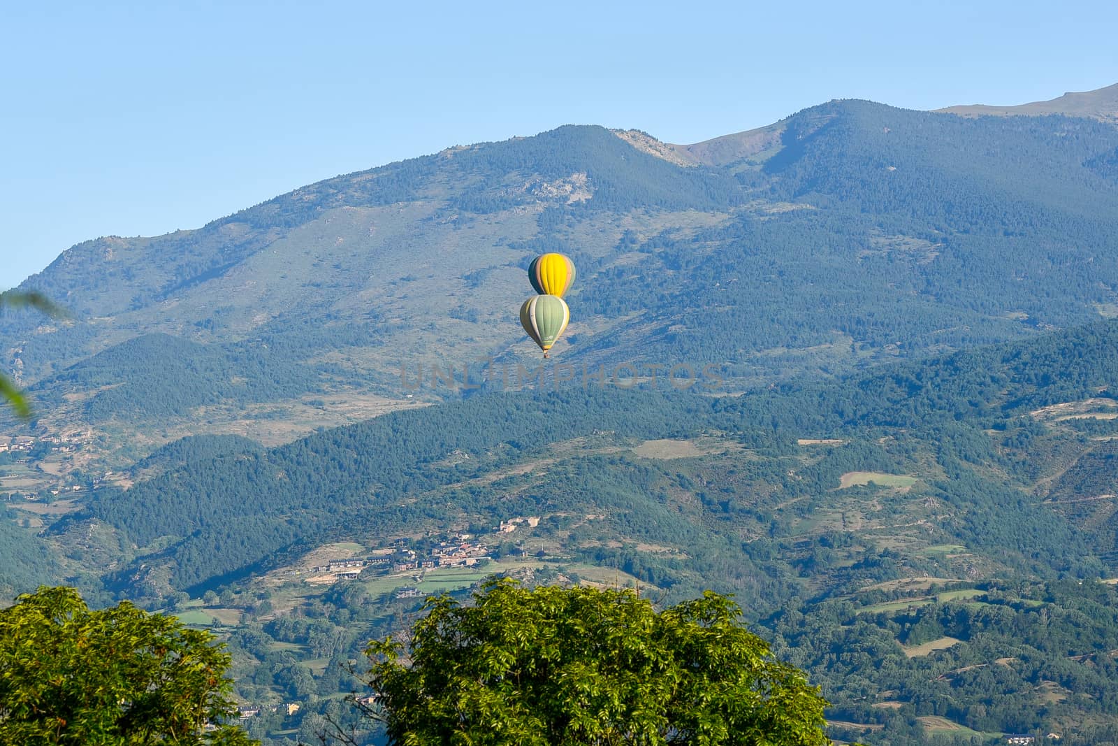 Colorful hot air balloons flying over the mountain in Puig Cerda, Spain.