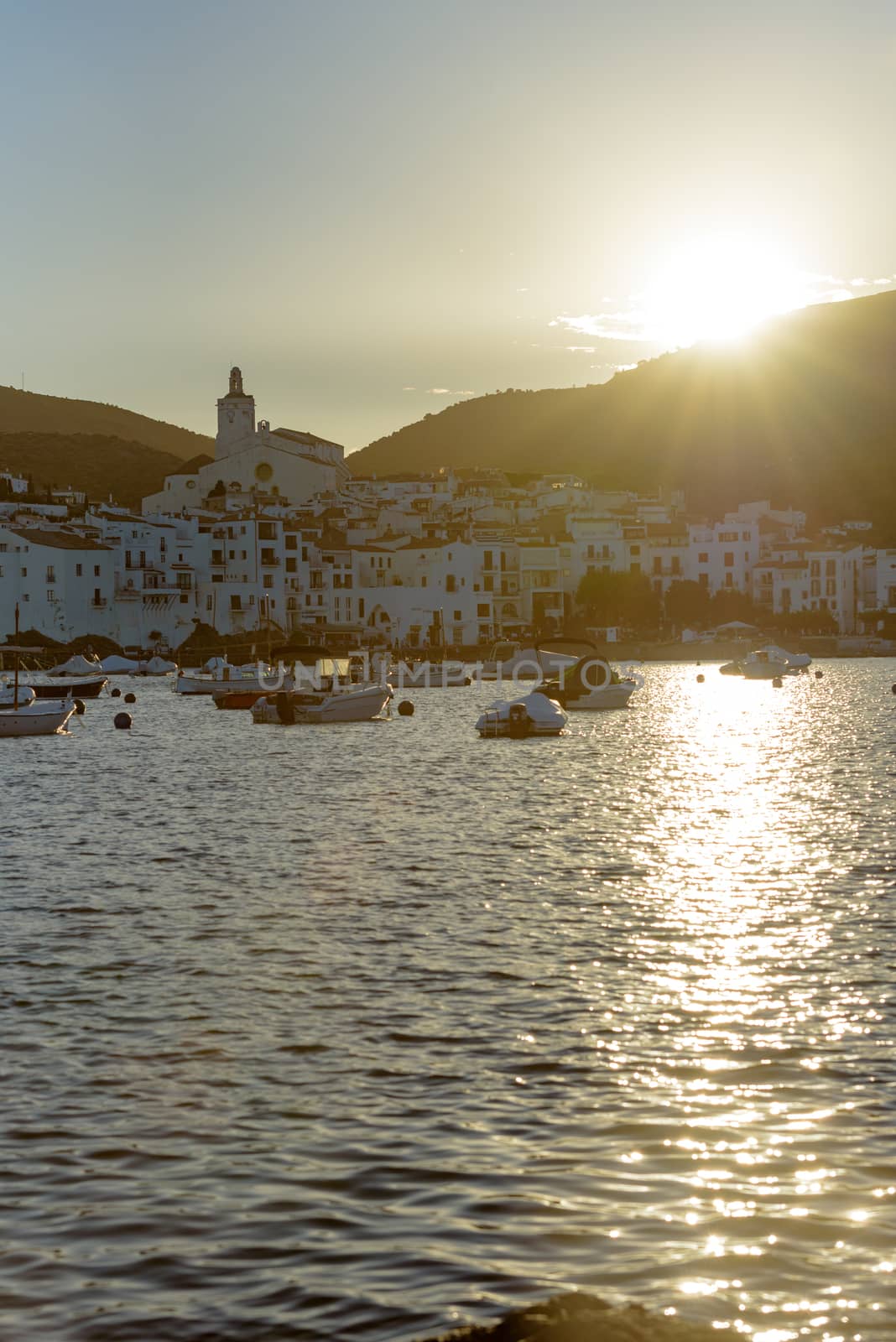Boats in the beach and houses of the village of Cadaques, Spain  by martinscphoto