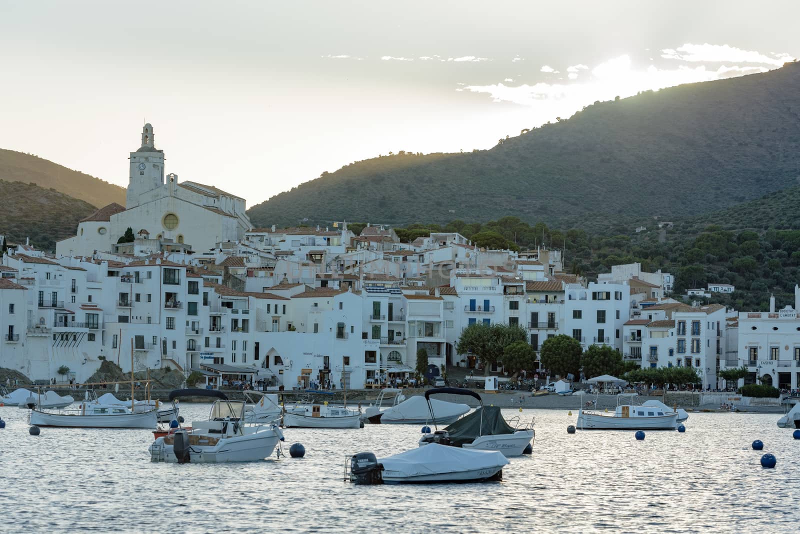 Boats in the beach and houses of the village of Cadaques, Spain  by martinscphoto