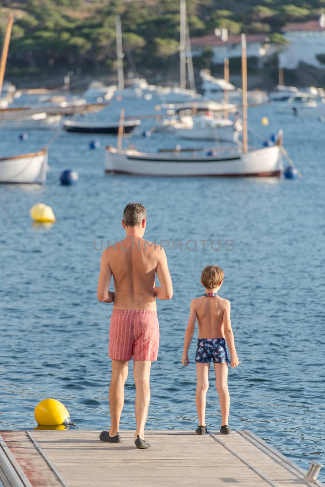 Cadaques, Spain : 07 JULY 2020 : People in the beach and houses of the village of Cadaques, Spain in summer on 07 july 2020.