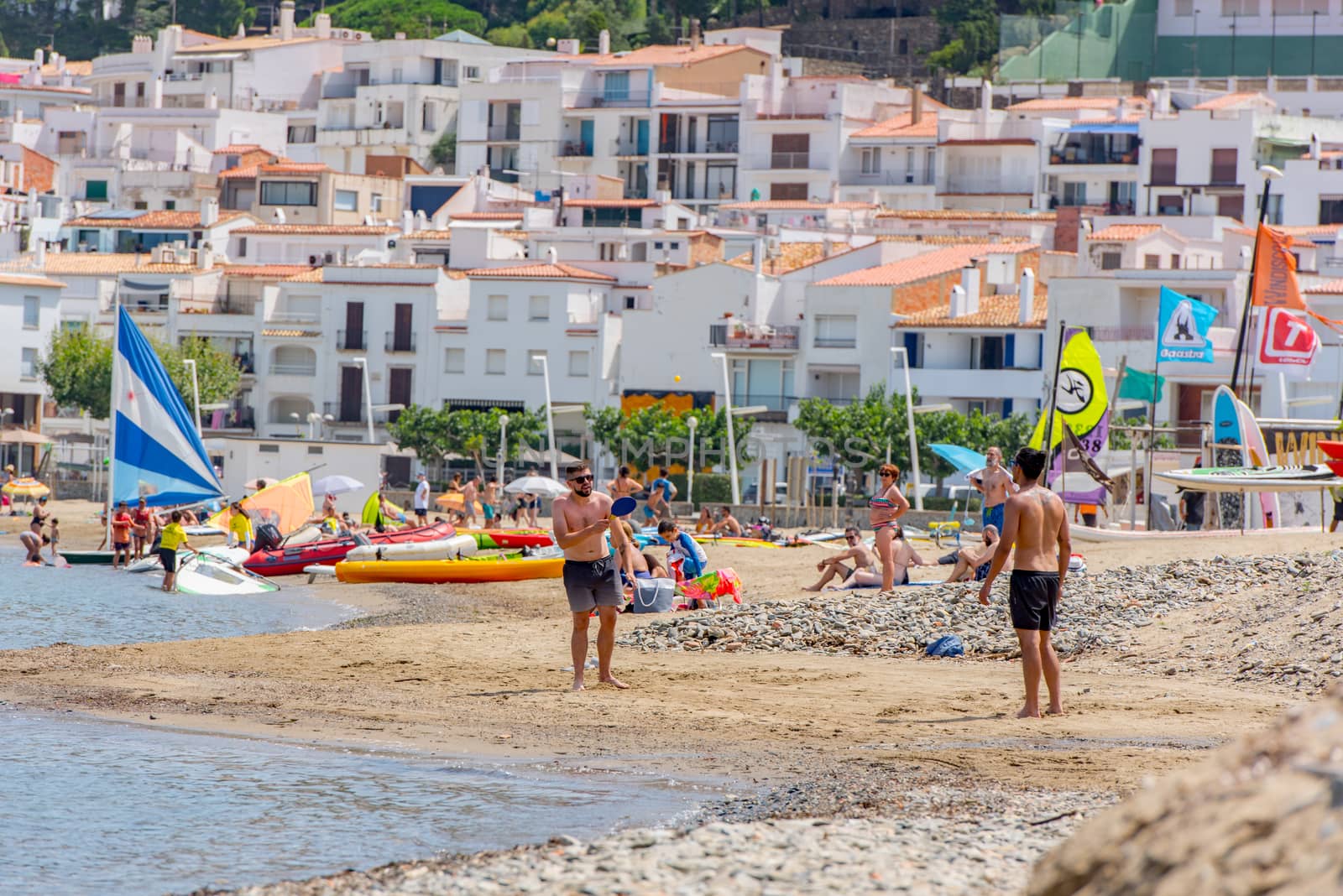 Port de la Selva, Spain : 9 July 2020 : People in the beach of Port de la Selva, one of the most touristic villages of Costa Brava, on August 9, 2013, in Port de la Selva, Catalonia, Spain.