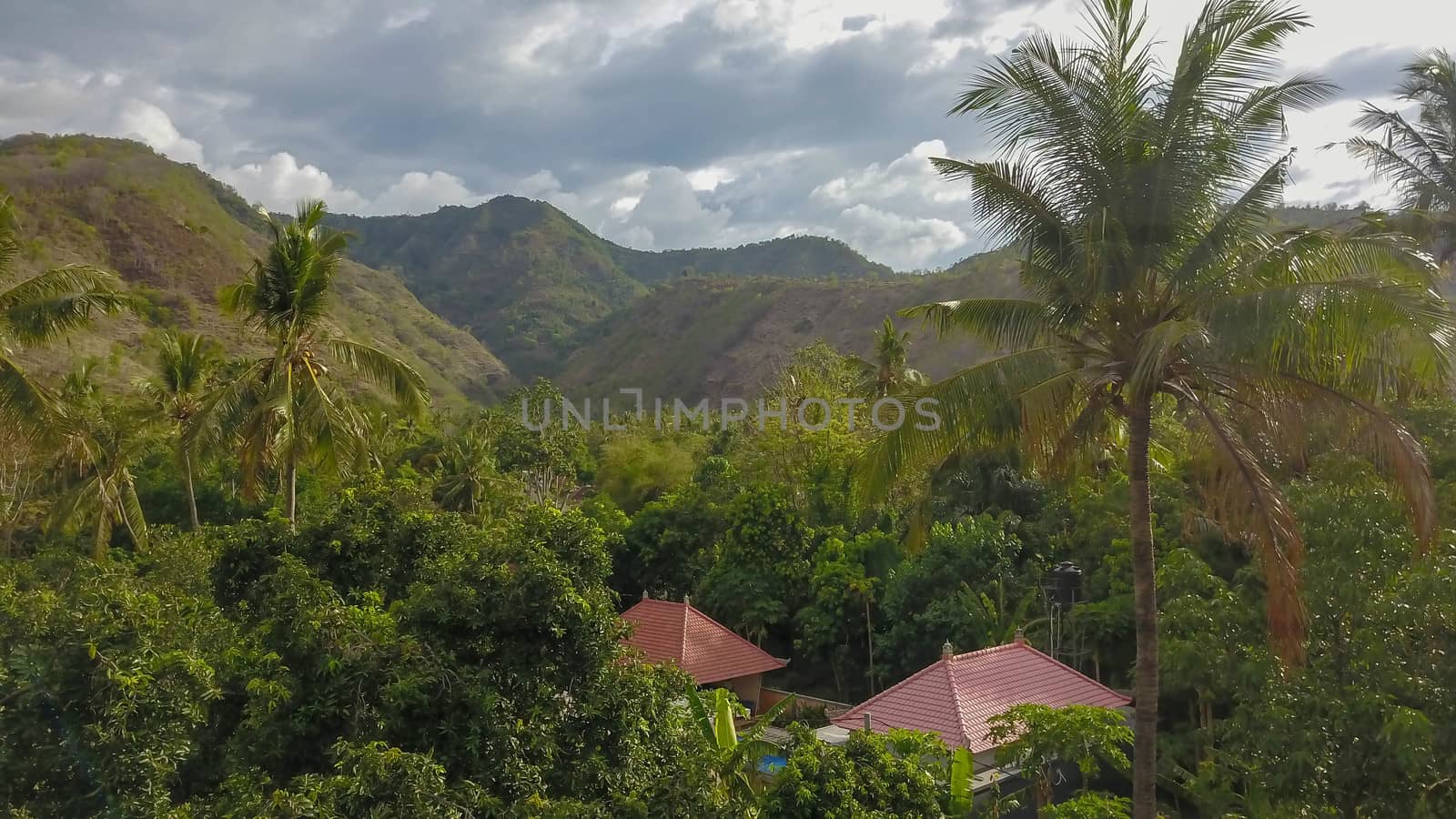 Living in wild. Small houses bungalow with red roof in Thai jungle, Koh Chang, Thailand. Panoramic asian countryside landscape with Thai wooden cottage in forest.