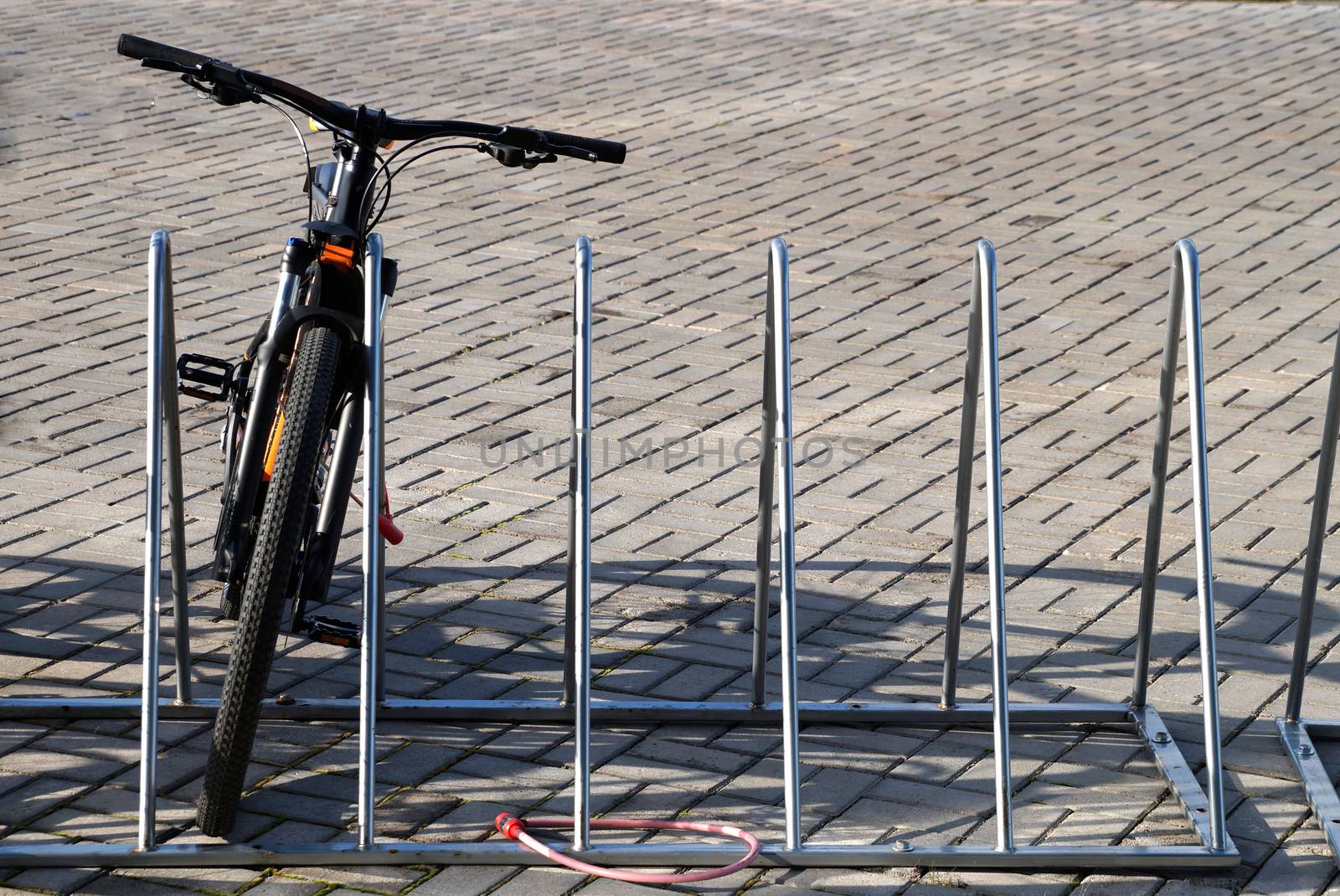 one bike in a bicycle parking on the street by Annado