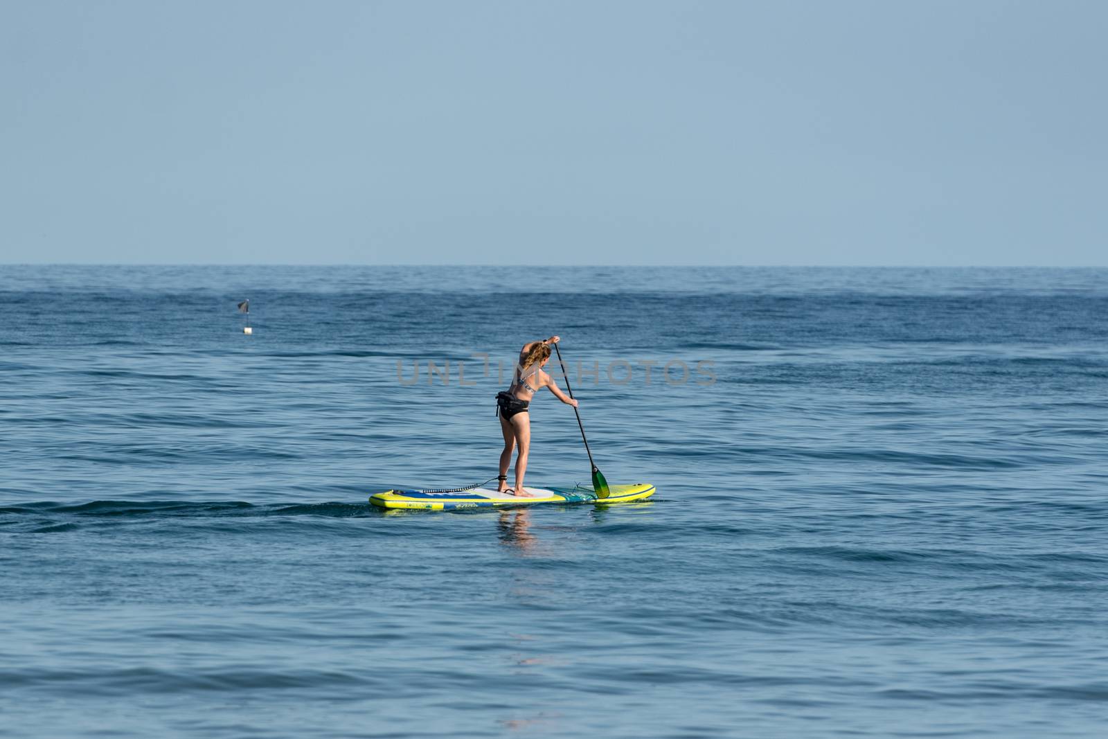 Castelldefels, Spain: 2020 June 25: People ride in Paddle Surf on the coast of Castelldefels in Barcelona in summer after COVID 19 on June 2020.
