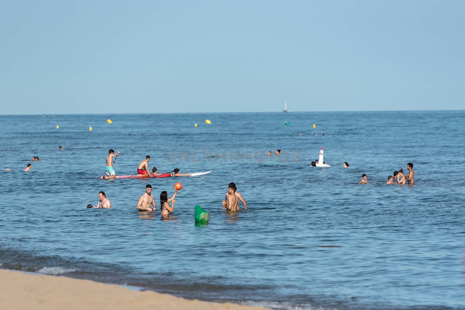 Castelldefels, Spain: 2020 June 25: People ride in Paddle Surf on the coast of Castelldefels in Barcelona in summer after COVID 19 on June 2020.