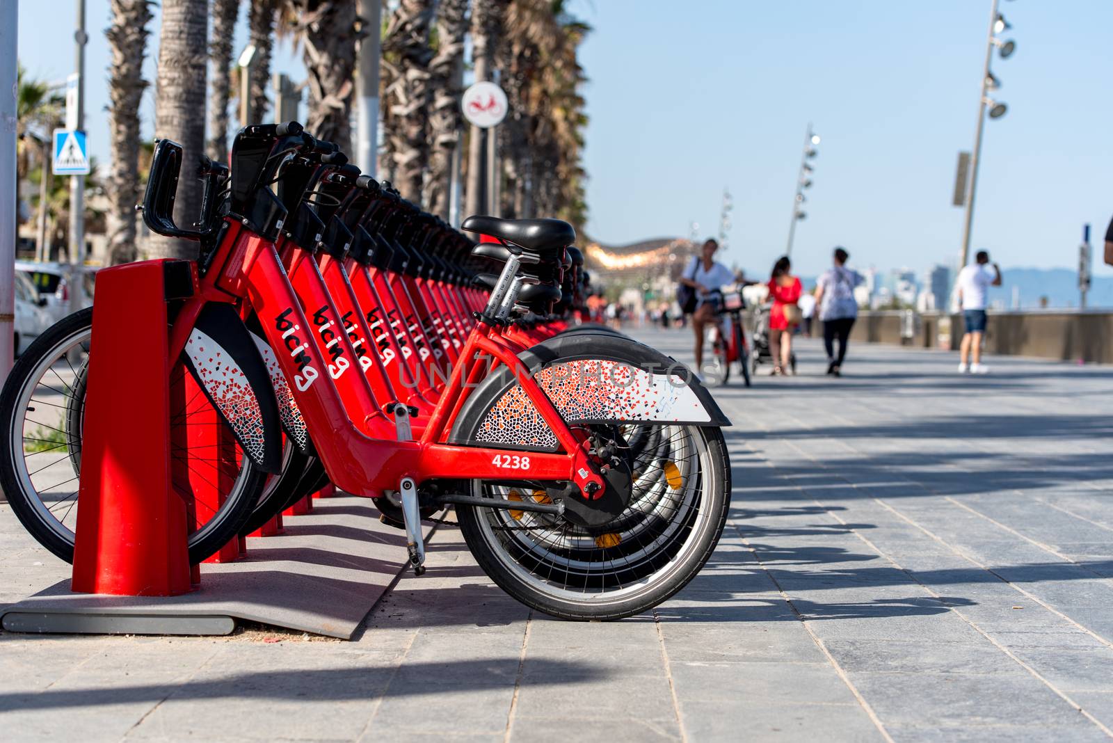 Barcelona, Spain - June 26, 2020: Bright red bicycles available for rent parked in a row at La Barceloneta. Concept of environmentally sustainable transport. Bike rental service Bicing.