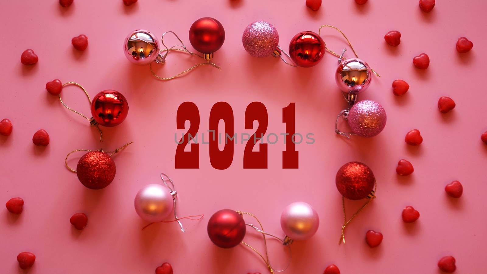 Festive frame made of christmas balls on pink table top view - 2021 year. Fashion background. Flat lay. Party mockup.