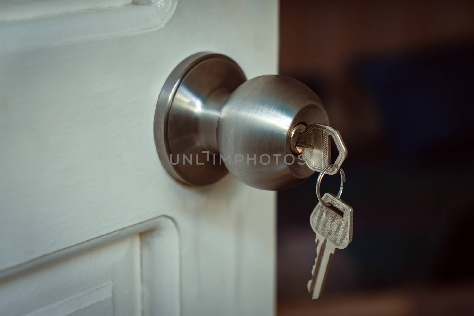 Key put in a knob lock on a white open door