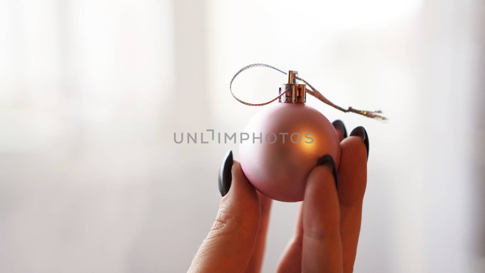 Christmas ball on hand with white blurred background