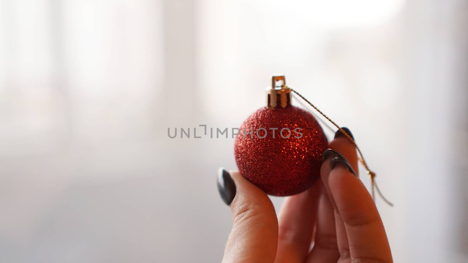 Christmas ball on hand with blurred background by natali_brill