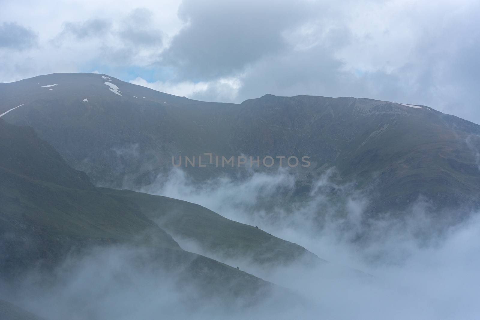 Sunny day with low clouds in the town of Pas de la Casa on the b by martinscphoto