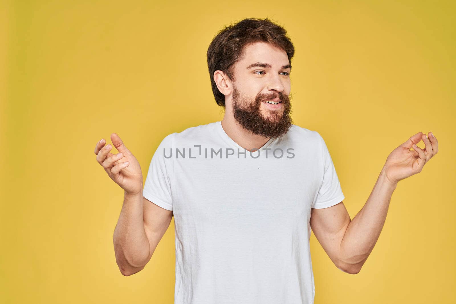 Bearded man on emotions white t-shirt fun lifestyle yellow background. High quality photo