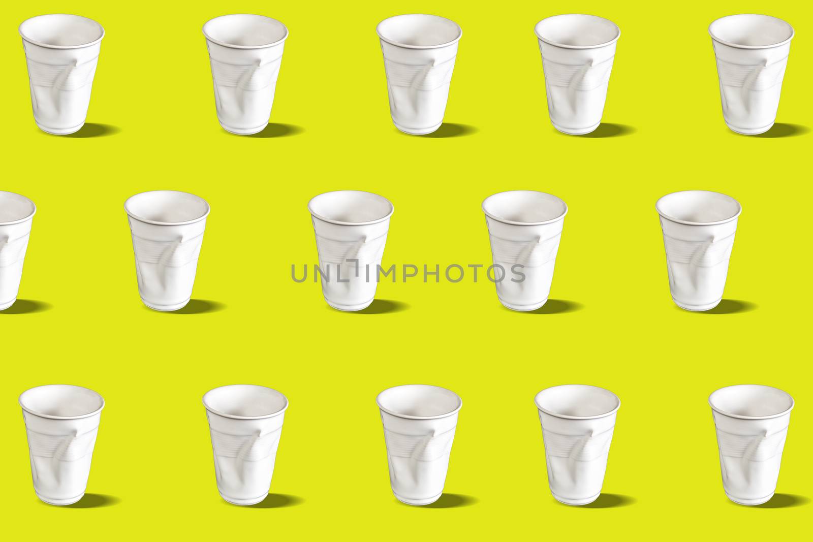 Disposable cups pattern. Disposable crumpled plastic water glasses. Pattern on a yellow background. Contemporary art. No 3D illustration