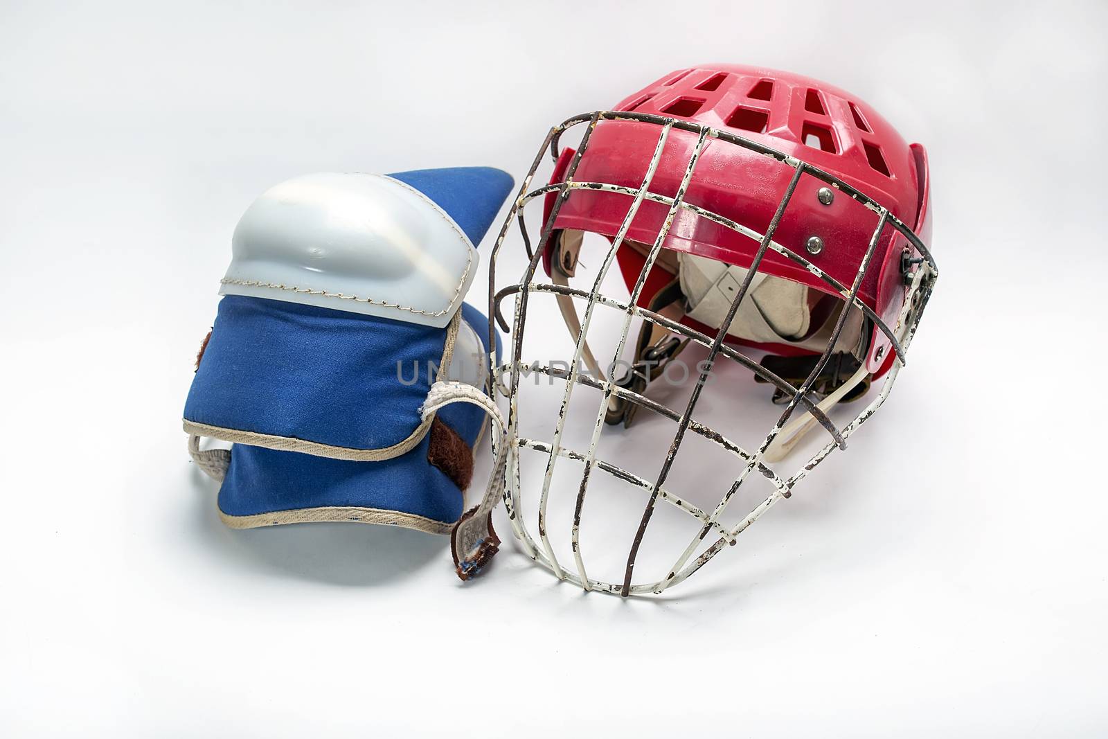 Old hockey helmet gloves and puck on a white background isolated.