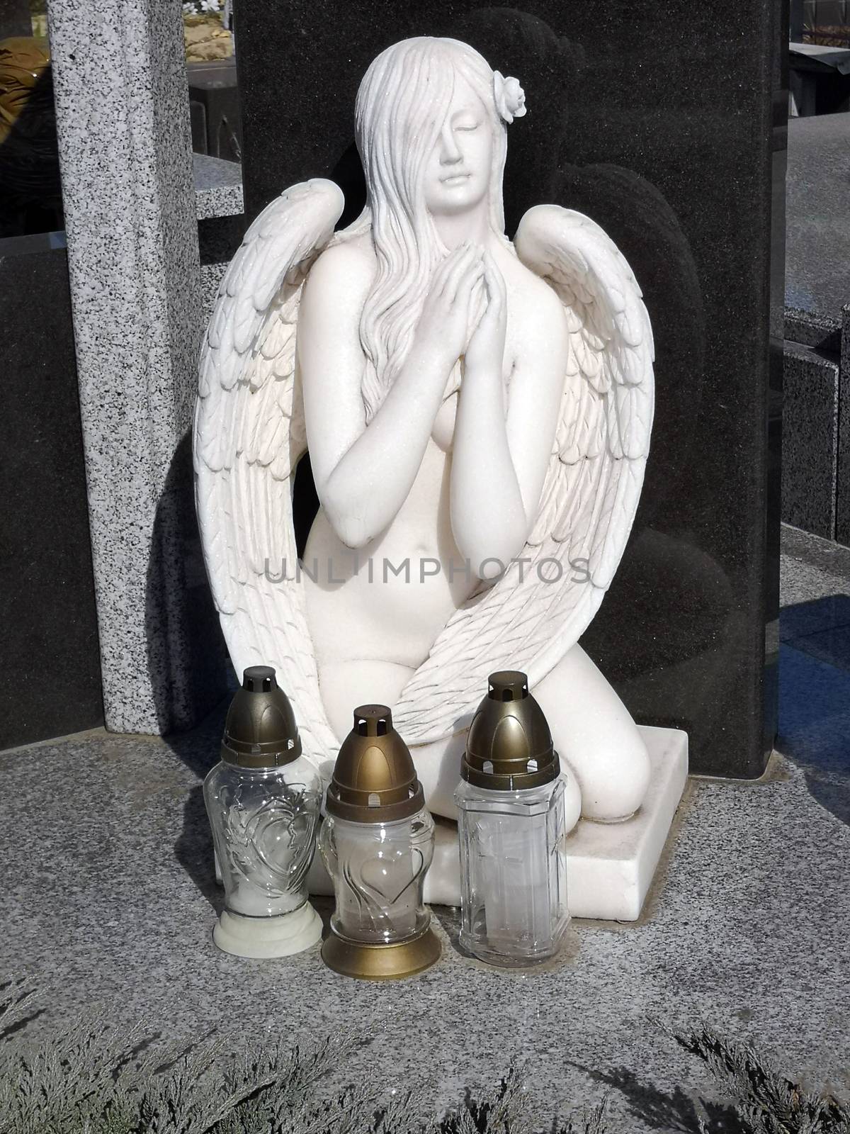 Cemetery monument in the form of an angel of white in front of her are three lomads 06.04.2020 Kiev Ukraine