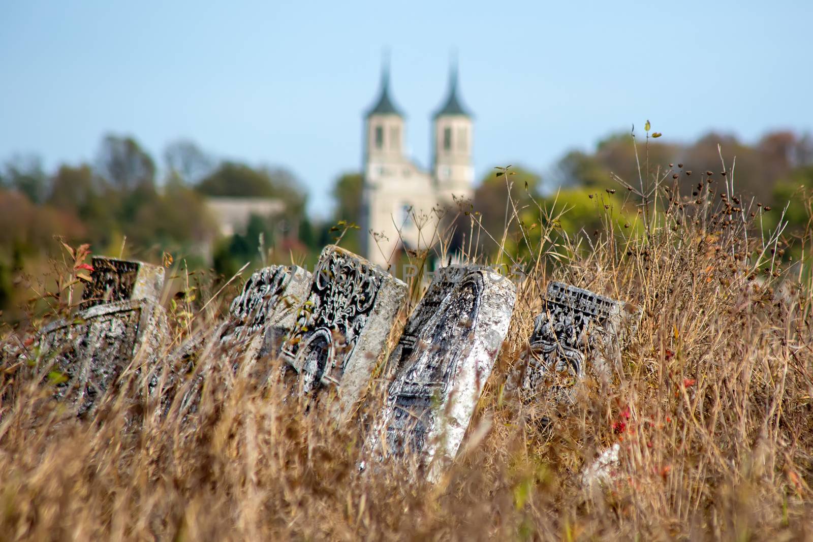 Graveyard plates in grass. Against the background of the church. by 977_ReX_977
