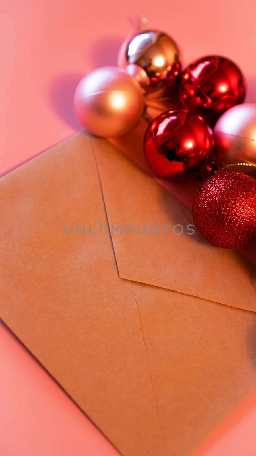 Envelope from craft paper with christmas red and pink balls on pink background by natali_brill