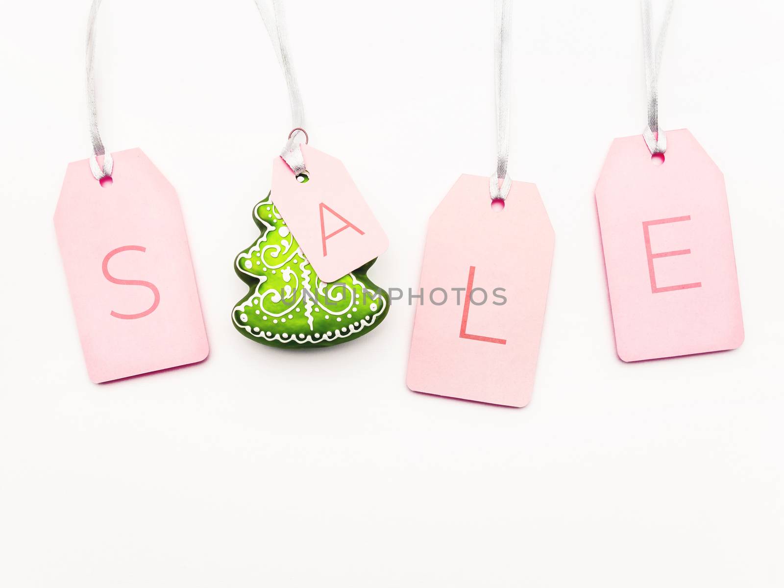 Four pink tags with word SALE and decorative Christmas tree on w by aksenovko