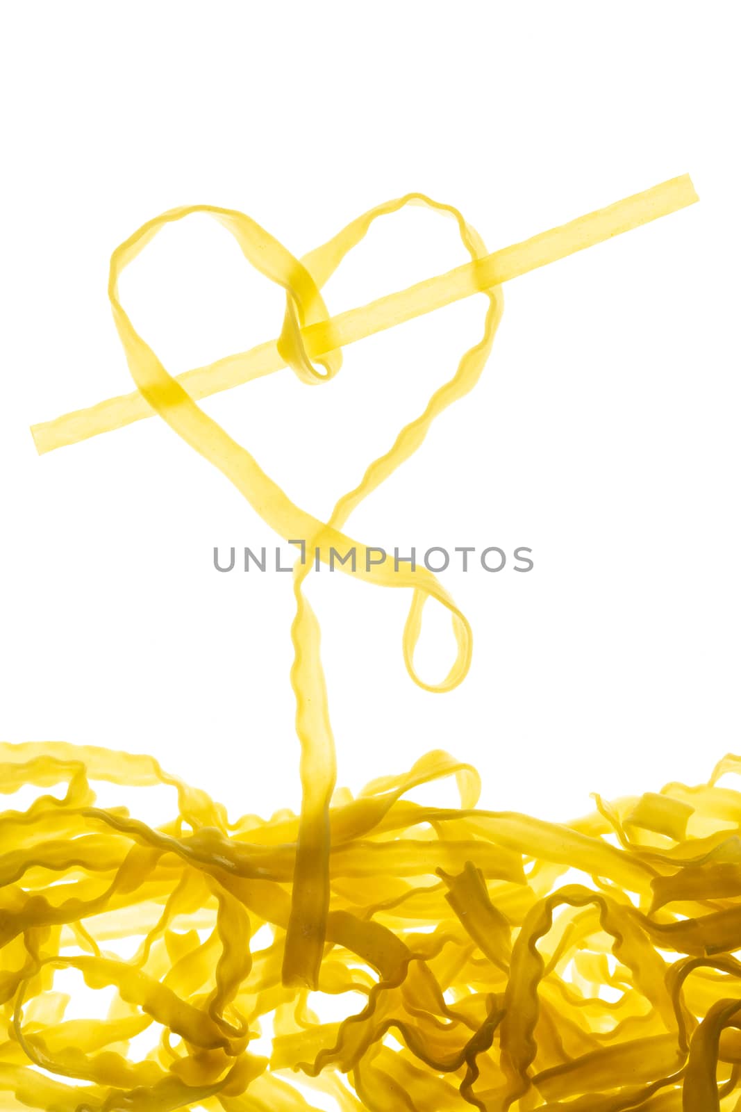 Swirls of cooked spaghetti with fork. Spaghetti heart shape