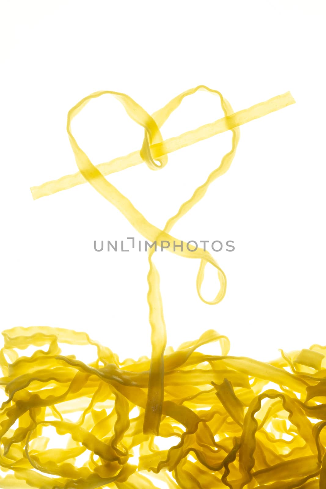 Swirls of cooked spaghetti with fork. Spaghetti heart shape. by sashokddt