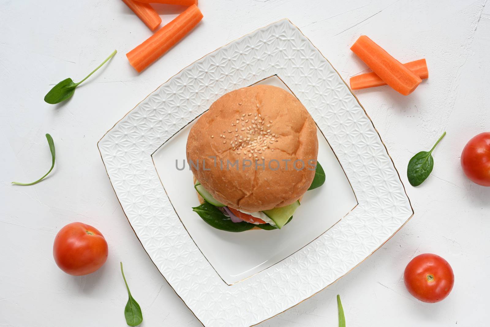 Milanese burger, with tomatoes, lettuce and french fries, in white background.