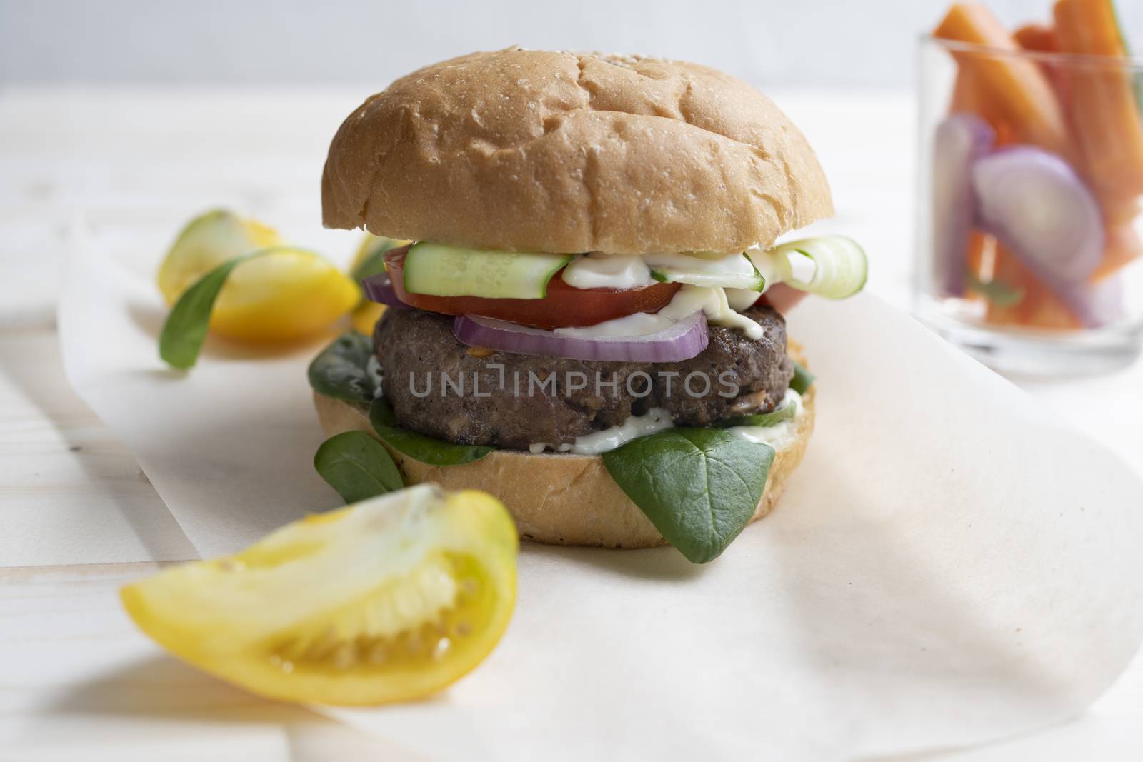 Milanese burger, with tomatoes, lettuce and french fries, in white background.