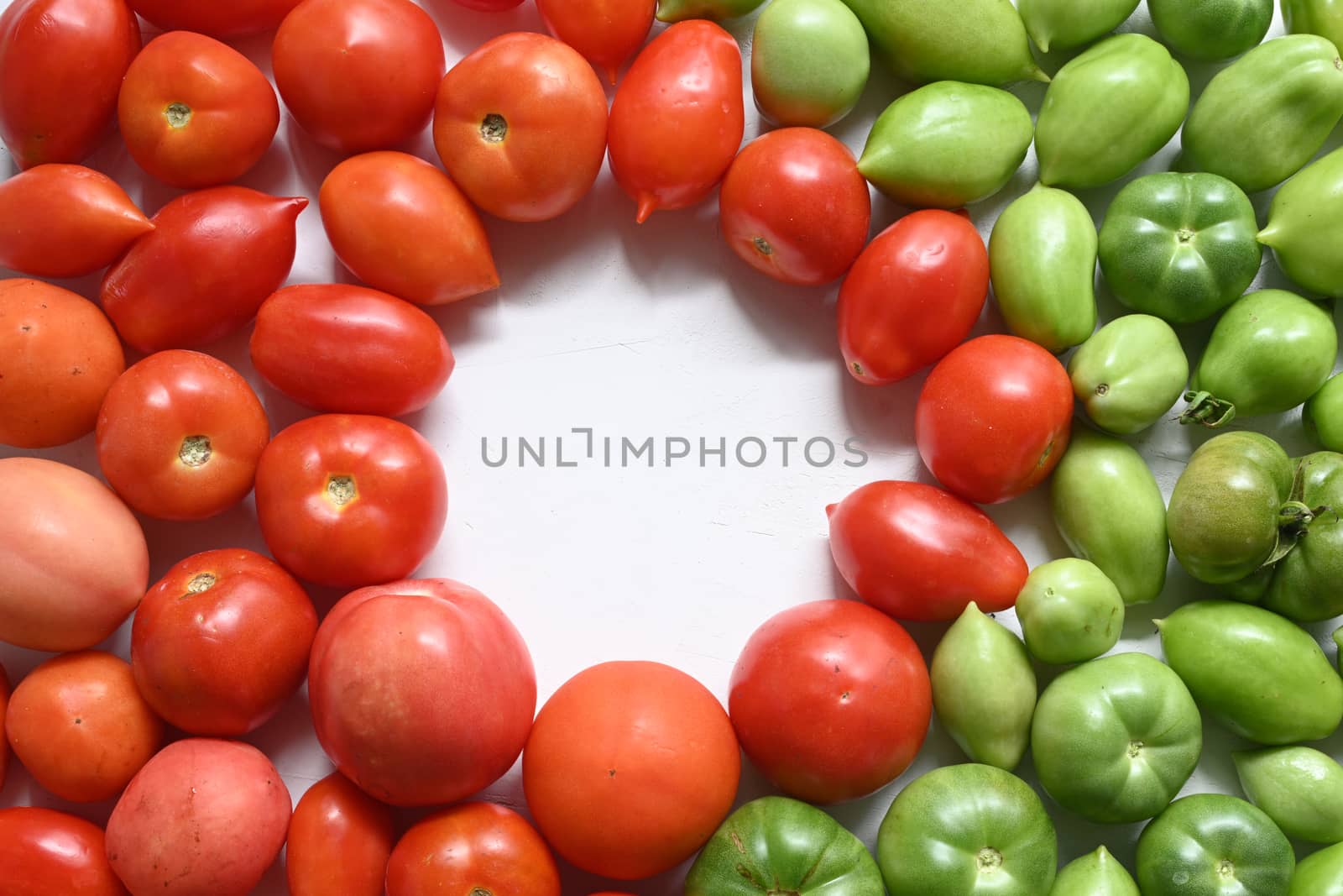 Optimal green and red tomatoes in the foreground. by sashokddt